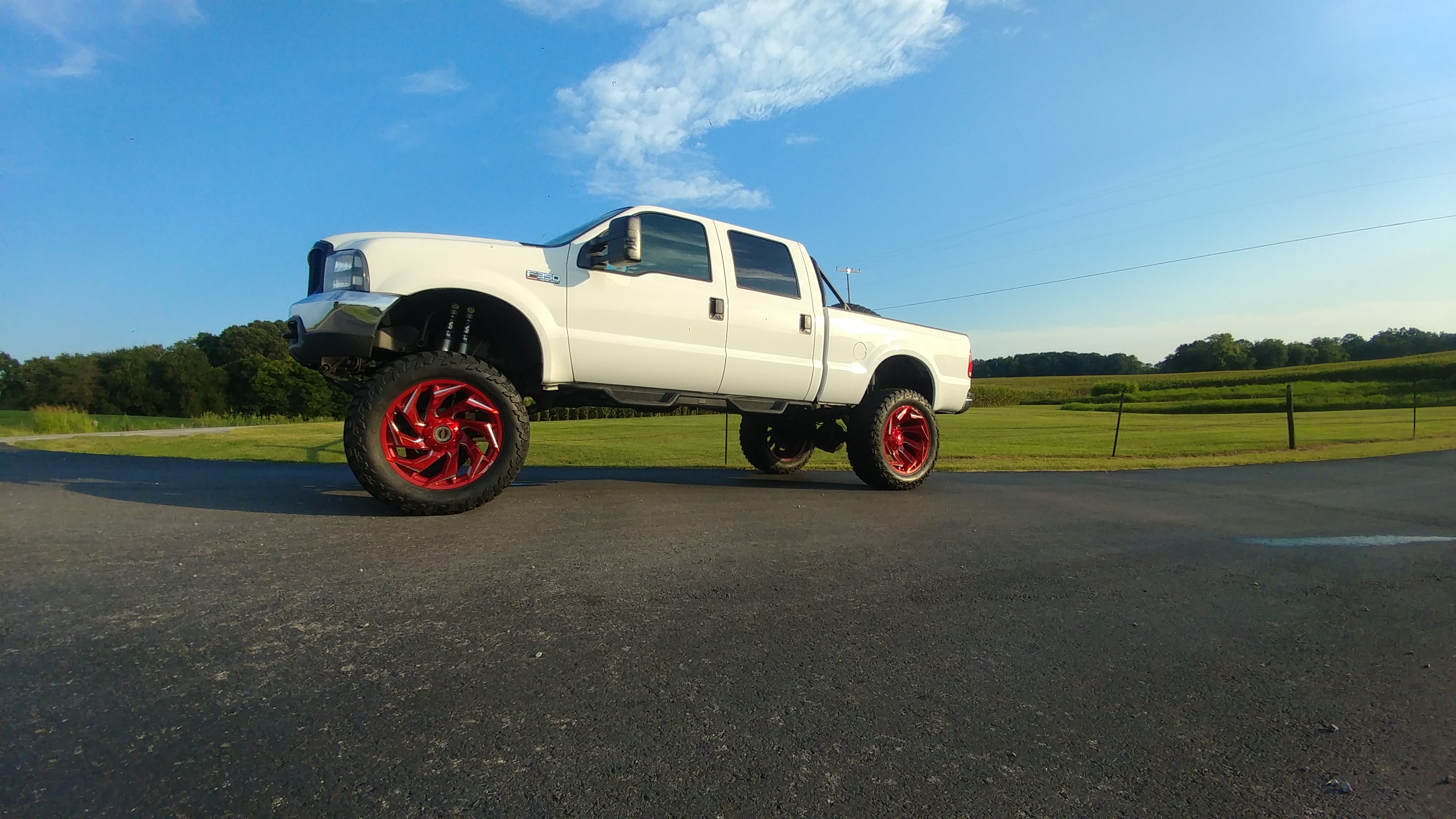 2001 Ford F-350 Lariat Crew Cab 4x4, white, on 40-inch tires and 24-inch red Fuel wheels